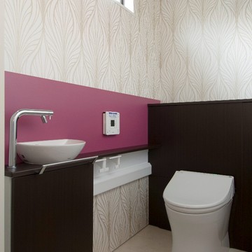 鮮やかなピンクと有機的な柄がモダンな壁紙が調和したオシャレなトイレ