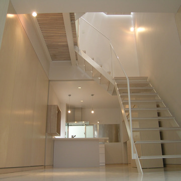 床壁天井の白い空間に建具や階段の踏み板が薄いベージュで優しい雰囲気
