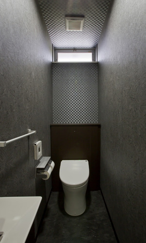 独特のテクスチャーの壁紙を仕様し、シックな雰囲気にまとめたトイレ