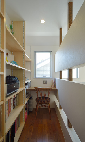 本棚の端に小窓から景色を楽しめる安心感ある書斎