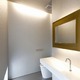 シルバーのクロスとゴールドのミラーの対比が、非日常的な空間を生み出しているトイレ