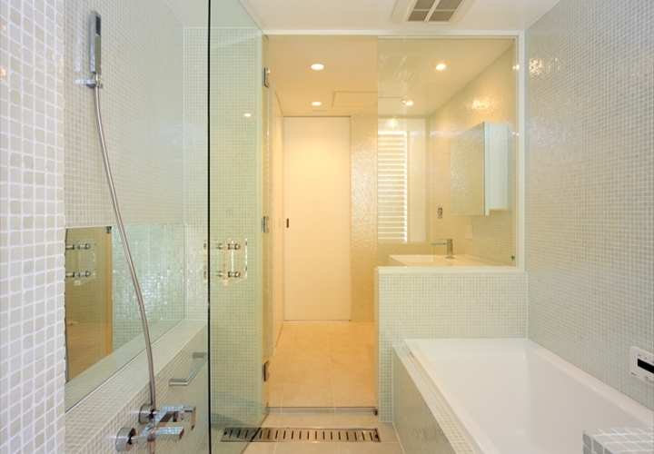 艶めく細かなタイルとガラスで明るい浴室