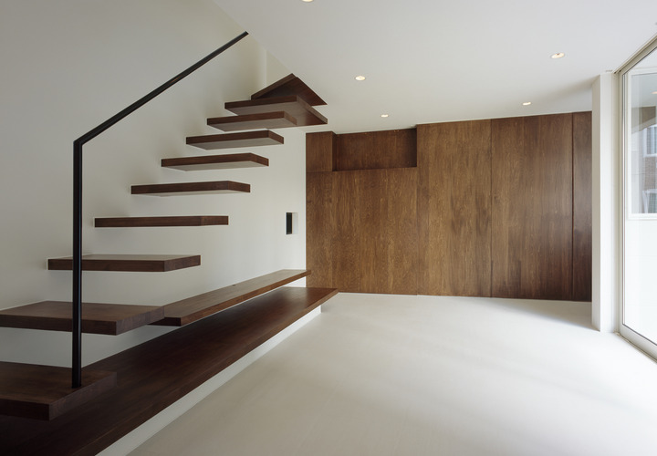 茶色でまとめた壁収納・階段・テレビボードが、重厚かつ雰囲気のあるリビング