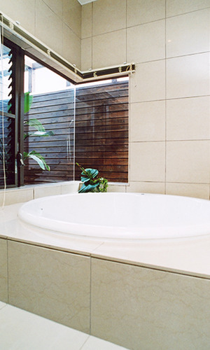 リゾート気分の丸い浴槽に自然光の注ぐ浴室