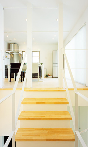 木のオープン階段からキッチンを眺める