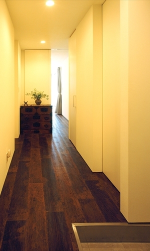 白い内壁と黒い床材と家具のコントラスト