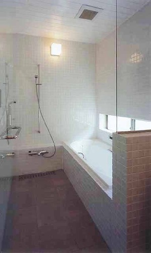壁面からタイルを使用し、清潔感のあるシンプルな浴室