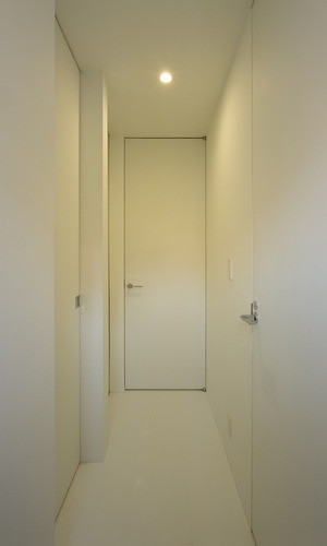 天井高まであるそれぞれの扉が、縦長の空間作りに役だっている廊下