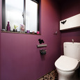 マゼンダカラーの壁と花柄の床が、ノスタルジックなトイレ