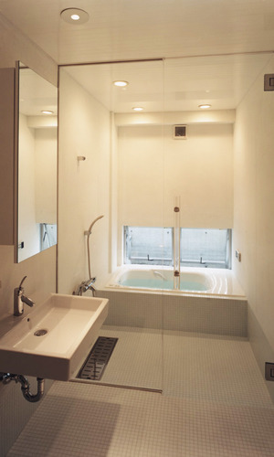浴室床と洗面床を同じ素材で統一し、清潔感で満たされている広さある浴室洗面所