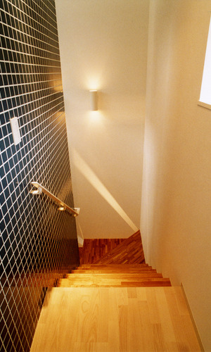 黒タイル壁・ステンレス手すりで、男前な空間に作り上げられた階段