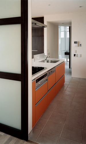 食欲を満たす料理を提供できそうな、側板のオレンジ色が魅力的なキッチン