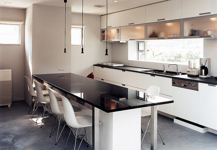 炭入りモルタル仕上げの床がよく似合う、白黒でまとめたモダンなダイニング・キッチン