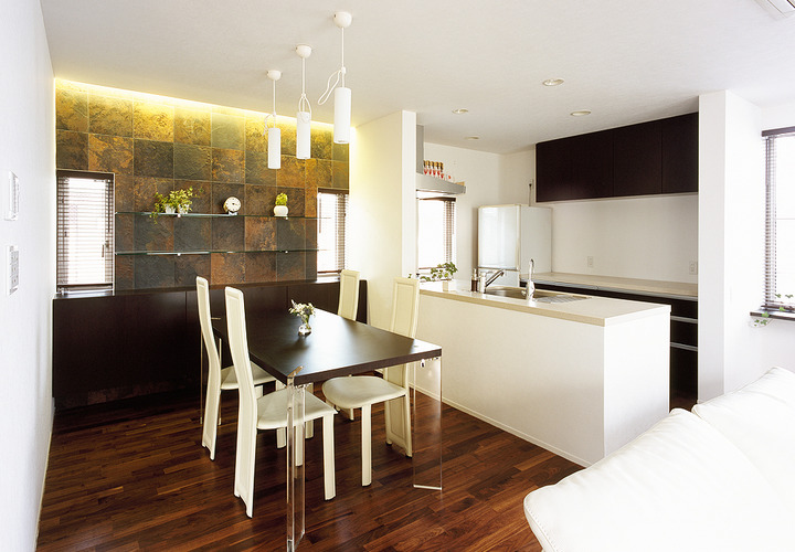 石貼りの壁が、気品ある家具とともに大人の余裕を感じさせるダイニングキッチン