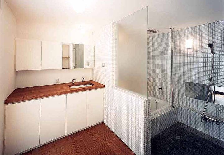白いタイルで浴室を包み込んだ、清潔感ある広い浴室