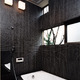 黒のタイルで統一した、窓からの四季を楽しめる在来浴室