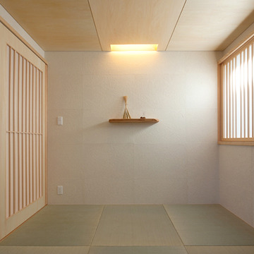 和紙の壁、縁なし畳のシンプルで落ち着いた和室。