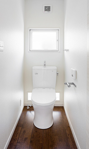 窓からやわらかな日差しが入る白で統一したトイレ