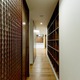 収納や、タイル張りの壁仕上げ材の色を合わせ、重厚感を演出した廊下