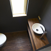 黒い壁とウッド調が落ち着きある雰囲気のトイレ
