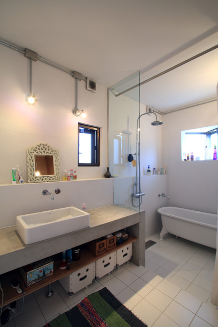 洗面スペースとの繋がりが美しいガラス張りのバスルーム
