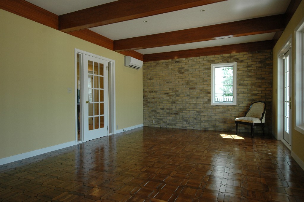 寄せ木細工の床にレンガの壁がアンティークな雰囲気の室内