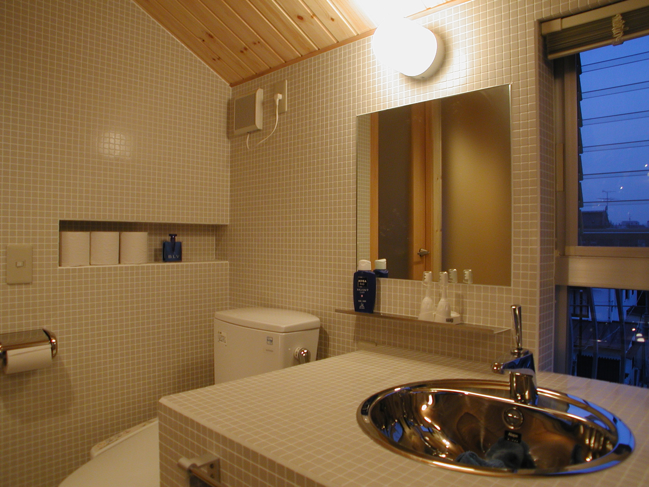床壁だけでなく洗面台もモザイクタイルでスマートな印象のトイレスペース