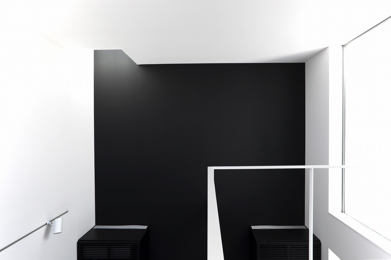 黒と白の壁に当たる光が、壁に立体的な表情を与える吹抜け