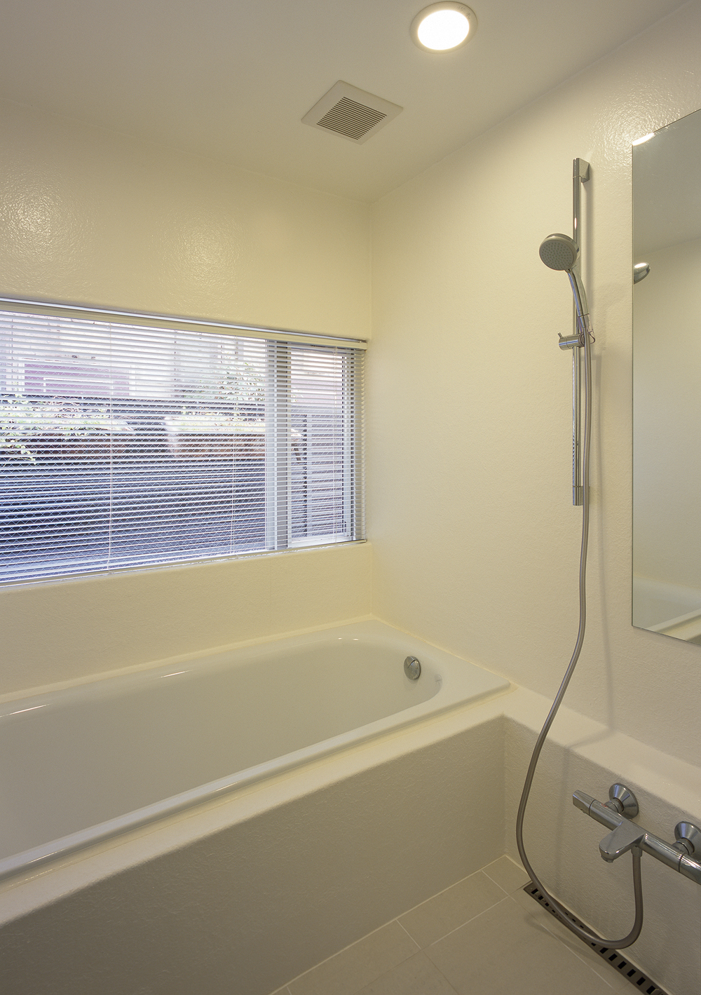 大きめの窓から、月光浴を楽しめる真っ白な在来浴室