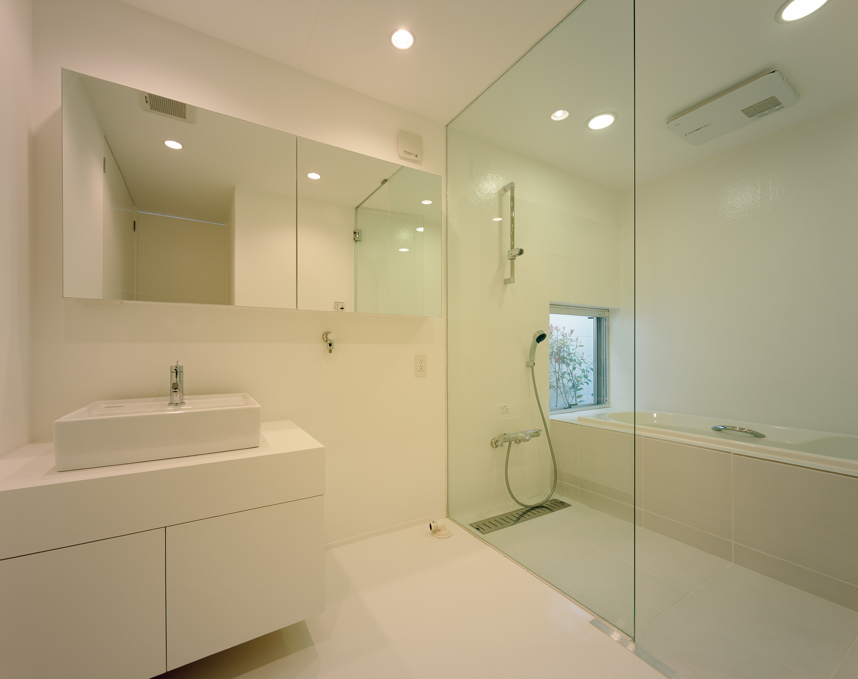 ガラスの壁・扉、鏡も洗面台も浮かせるようなデザインが、空気を軽く感じる洗面・浴室