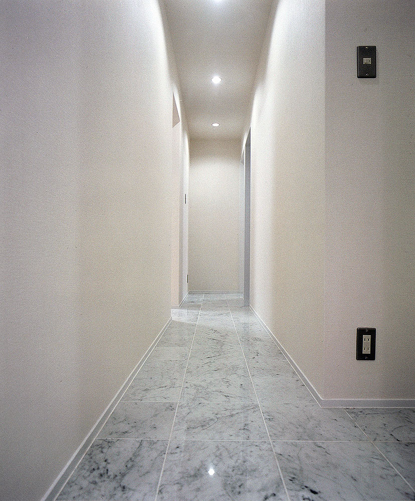 床を大理石調タイルでまとめた、シックでクールな印象の廊下