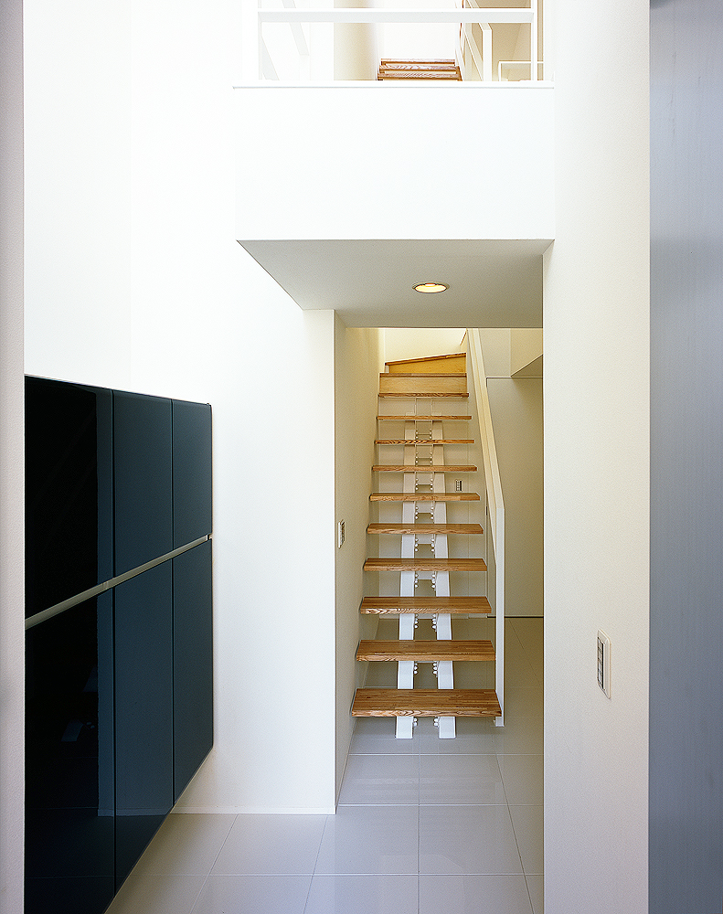 白い壁に、そっと寄り添うように配置されたシンプルな階段