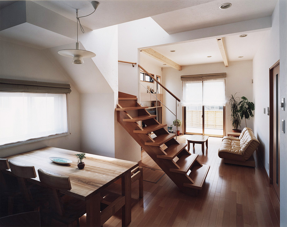 ダイニングキッチンとリビングの間の視線を区切るように配置された階段