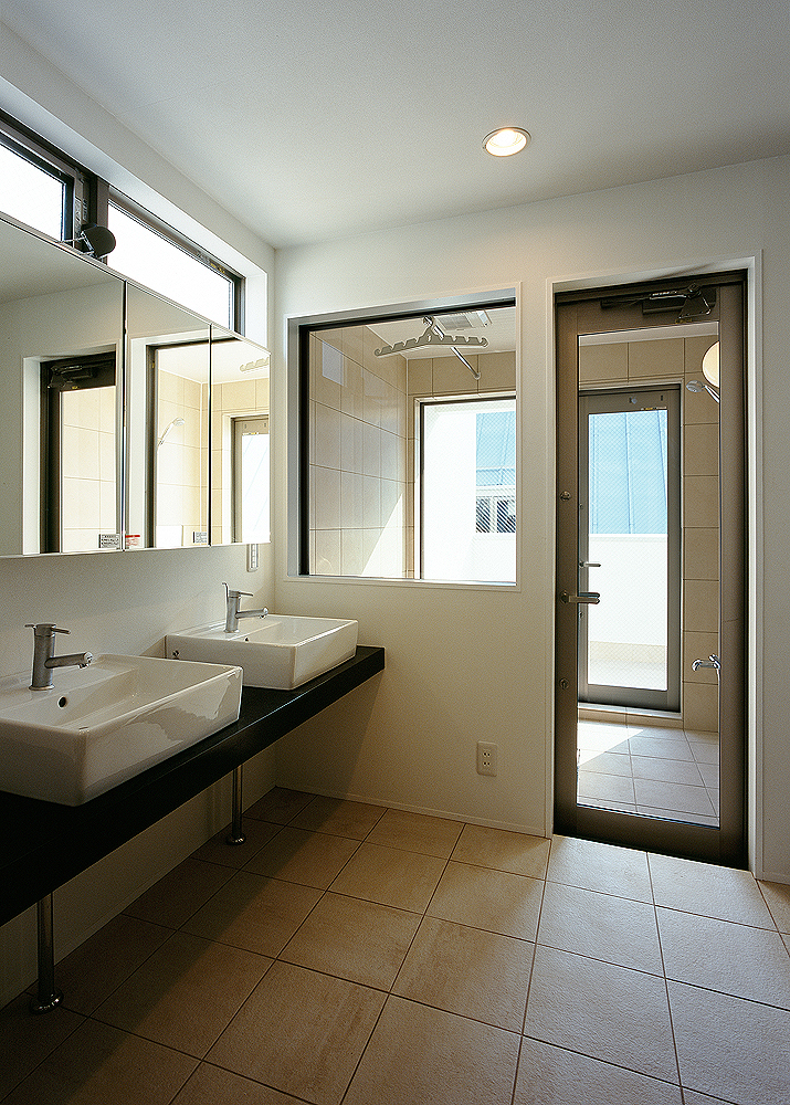 浴室・洗面で同じタイルを使用した、ガラス面の多い爽やかな空間