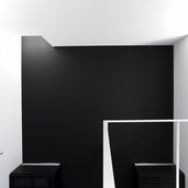 黒と白の壁に当たる光が、壁に立体的な表情を与える吹抜け