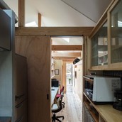 キッチン、事務所、玄関土間のつながり。事務所の床は土足利用も想定して杉足場板。