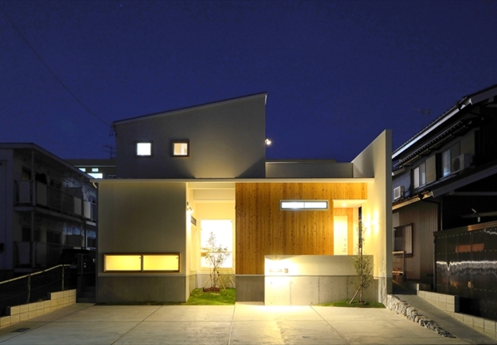 シンプルな白い壁と温かみのある木の質感が浮かび上がる夜景