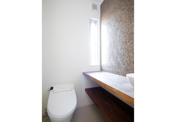 ブラウン調のタイルを貼って落ち着いた印象のトイレスペース