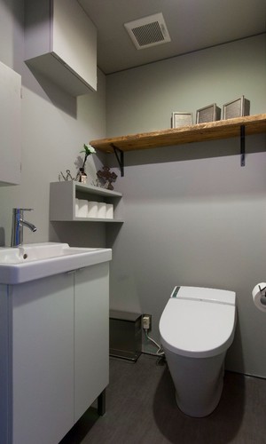 シンプルな空間に木目の飾り棚が味になるトイレ
