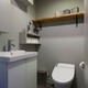 シンプルな空間に木目の飾り棚が味になるトイレ