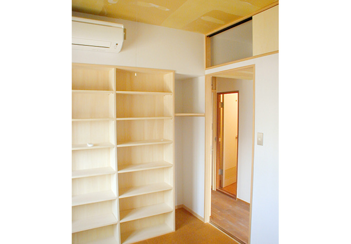 壁面いっぱいの本棚と廊下上の収納