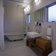 薄いグレーの床壁に白い洗面台や置き浴槽が素敵なバスルーム
