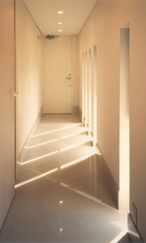 玄関から続く廊下スペースは白い空間に光の陰影が印象的なスリット窓