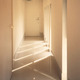 玄関から続く廊下スペースは白い空間に光の陰影が印象的なスリット窓