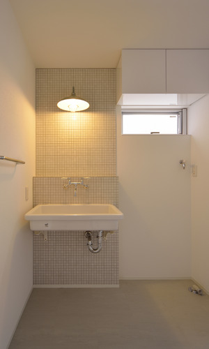 モザイクタイルや業務用洗面台が個性ある照明と共存する浴室・洗面所