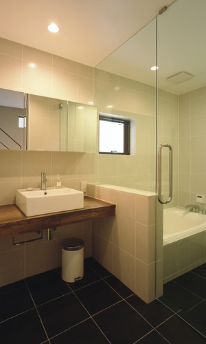 目地の少ないすっきりとした印象を与える、大きめのタイルを用いた洗面所・浴室