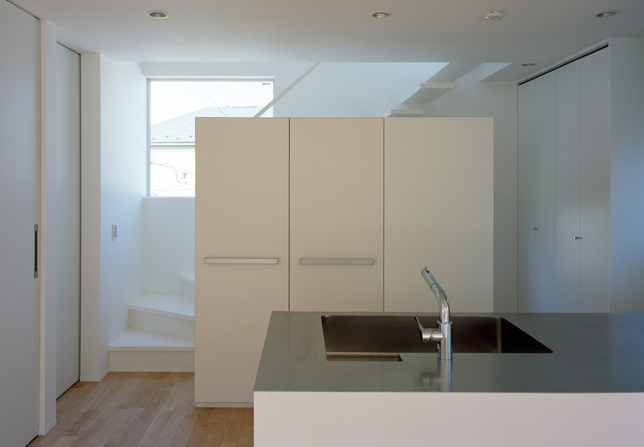 シンプルな階段を、デザイン性の高いキッチン収納で隠したキッチン周り