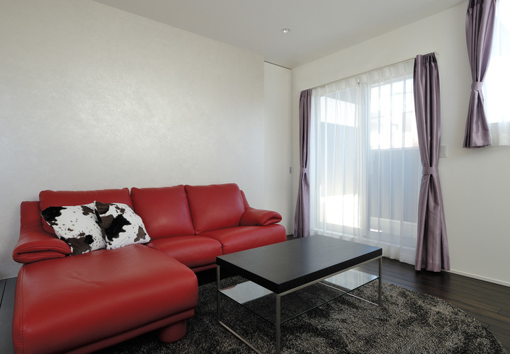 赤い革張りのソファが、こだわりのある空間作りに華を添えるリビング