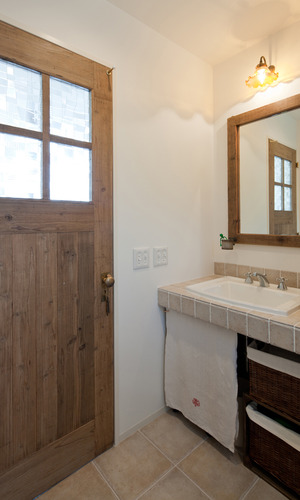 輸入洗面器とタイル、建具と鏡の枠は古木を再利用して作られた一品物と、こだわりぬいた洗面所