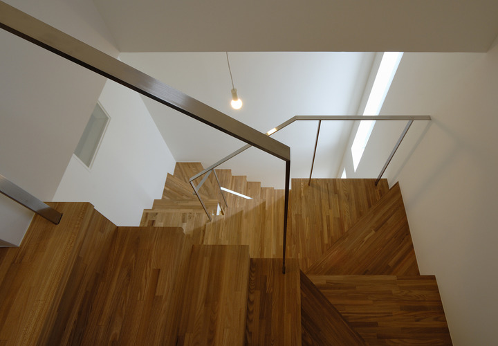 スリット窓からの光が広がる、立体的に繋がる階段